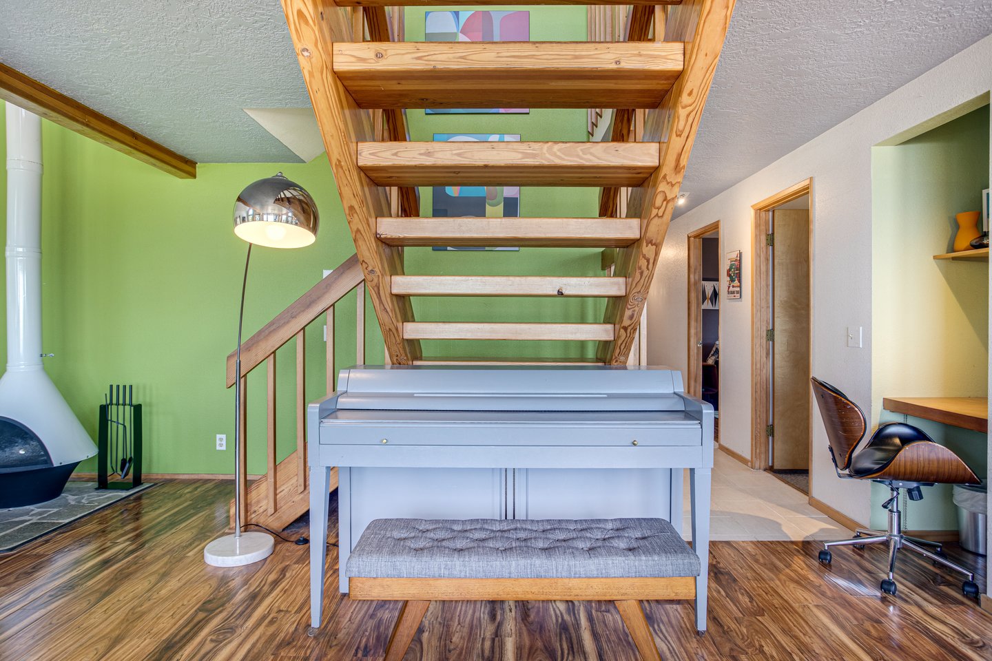 A piano for the family musician under the wide stairway.