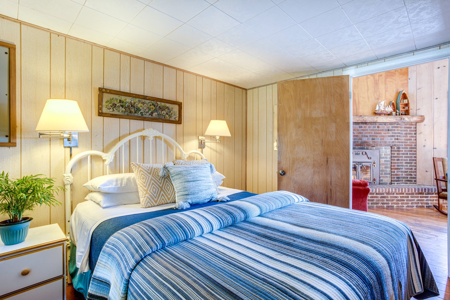The downstairs bedroom shares the warmth of hardwood flooring and classic furnishings