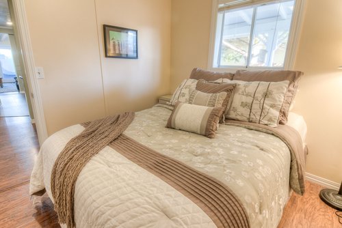 Two bedrooms with queen beds and hardwood flooring.