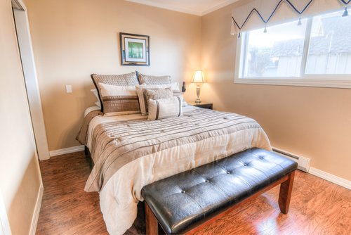 Two bedrooms with queen beds and hardwood flooring.