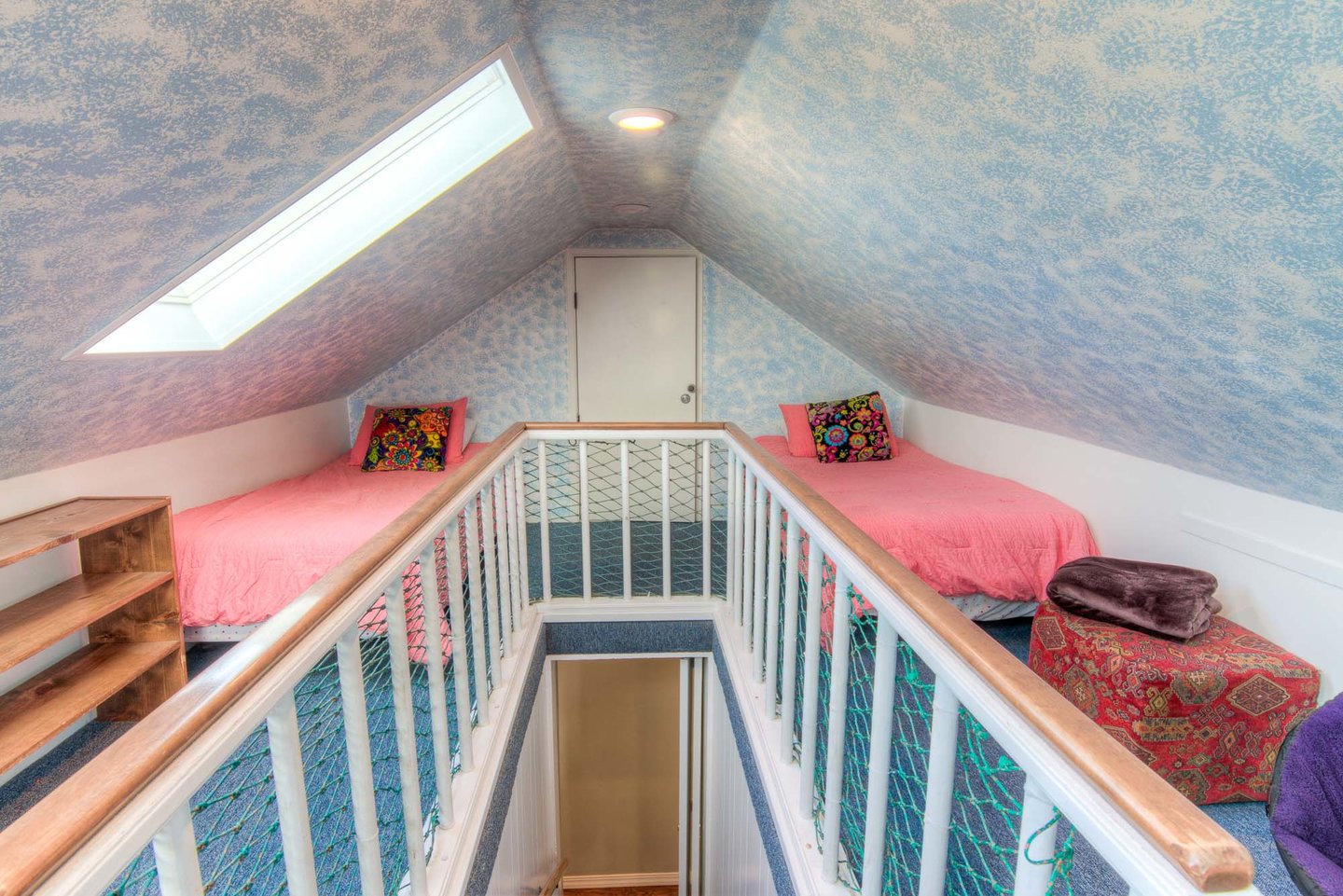 A sleeping loft with a queen bed and three twins