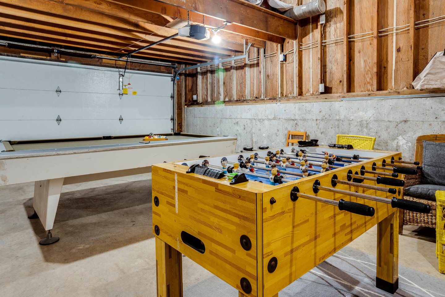 Game room in garage with fooseball and pool table.