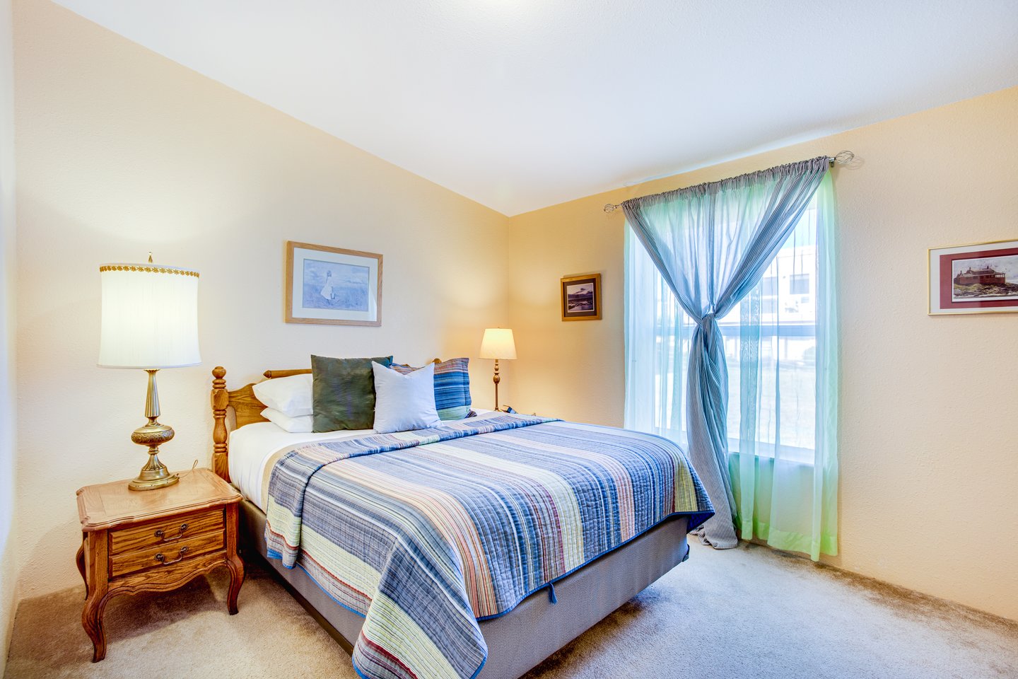 Queen bed in sunlit comfort in second bedroom.