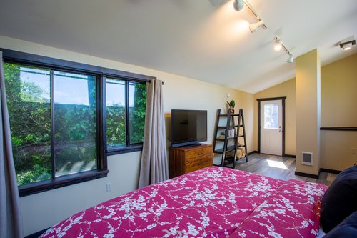 Detached loft  second bedroom above garage is illuminated by large picture windows .