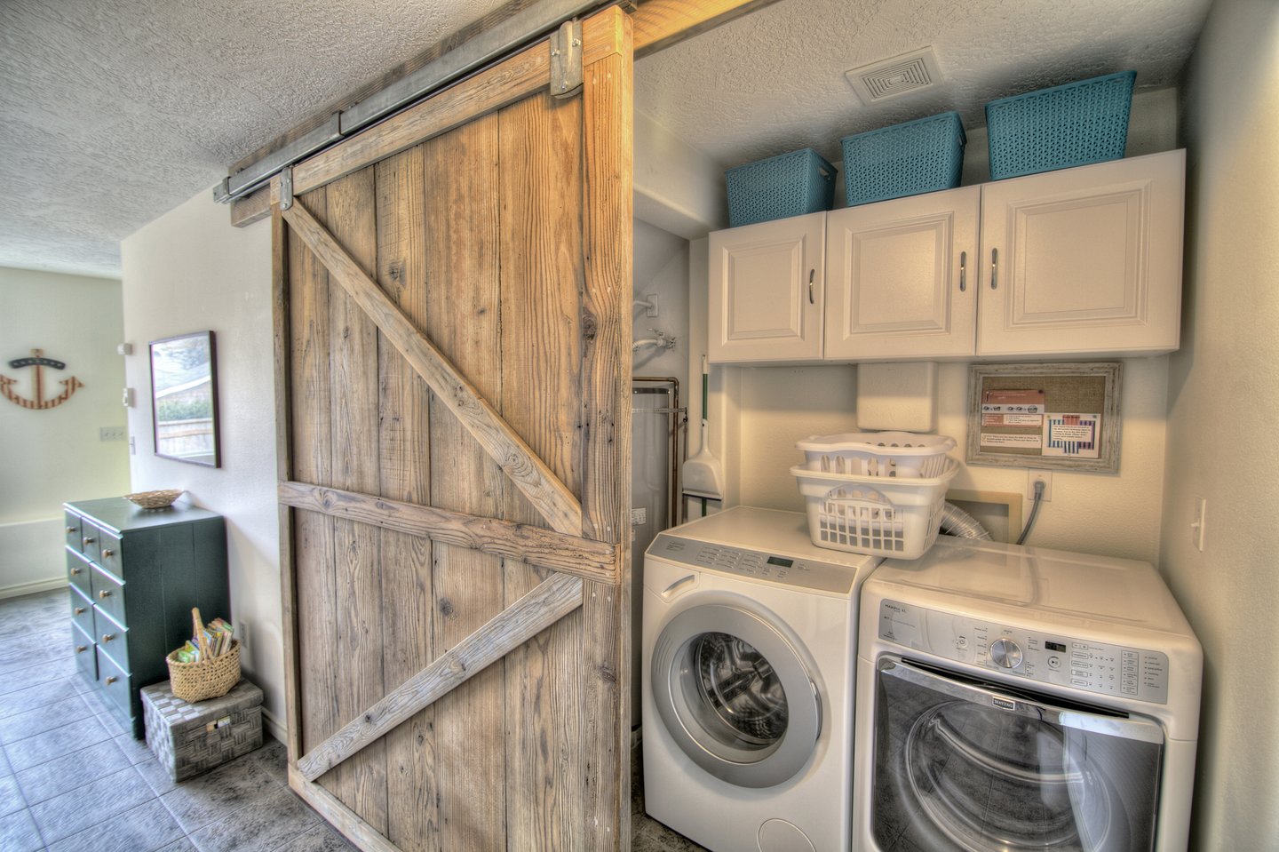 The washer/dryer is tastefully concealed behind a reclaimed sliding barn door.