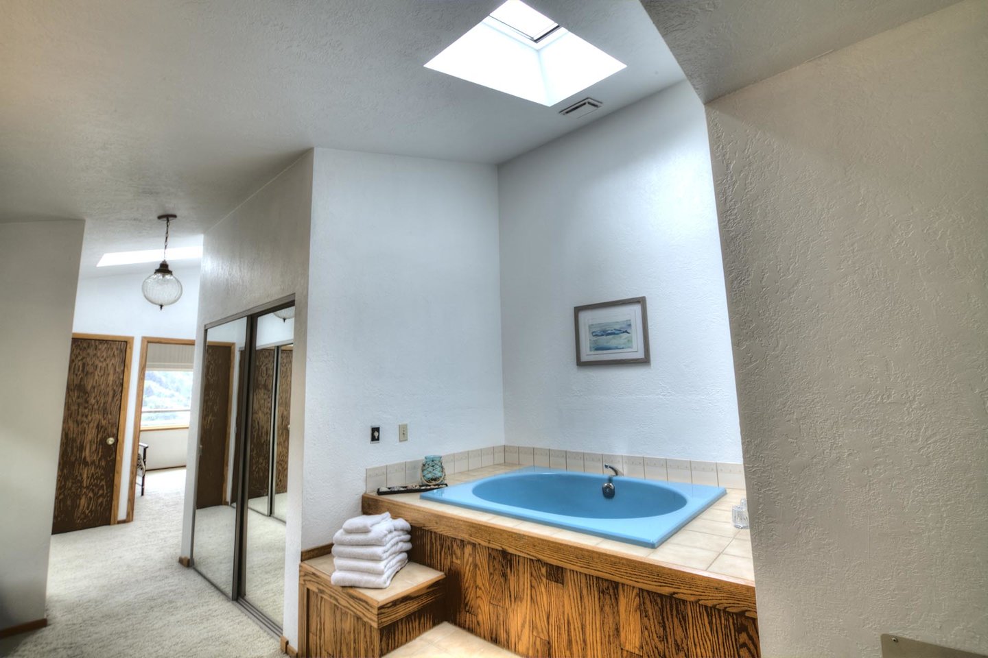 Deep soaking tub and skylight, an azure oasis.