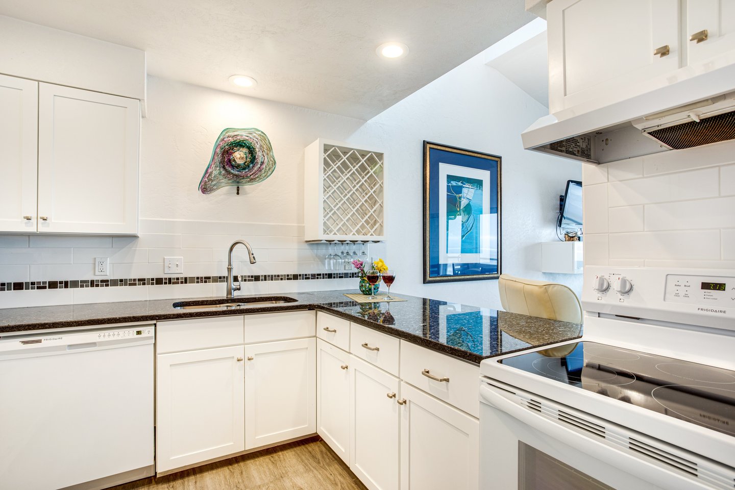 Sleek cabinetry and granite countertops in this bright well-lit kitchen