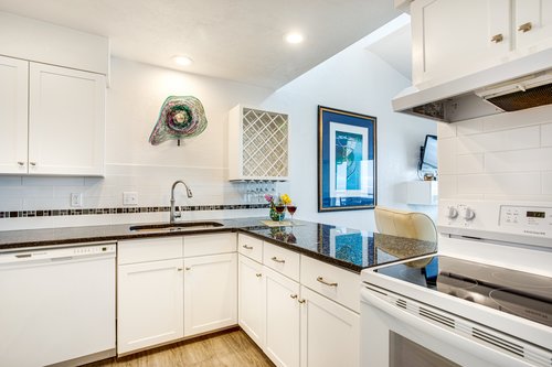 Sleek cabinetry and granite countertops in this bright well-lit kitchen