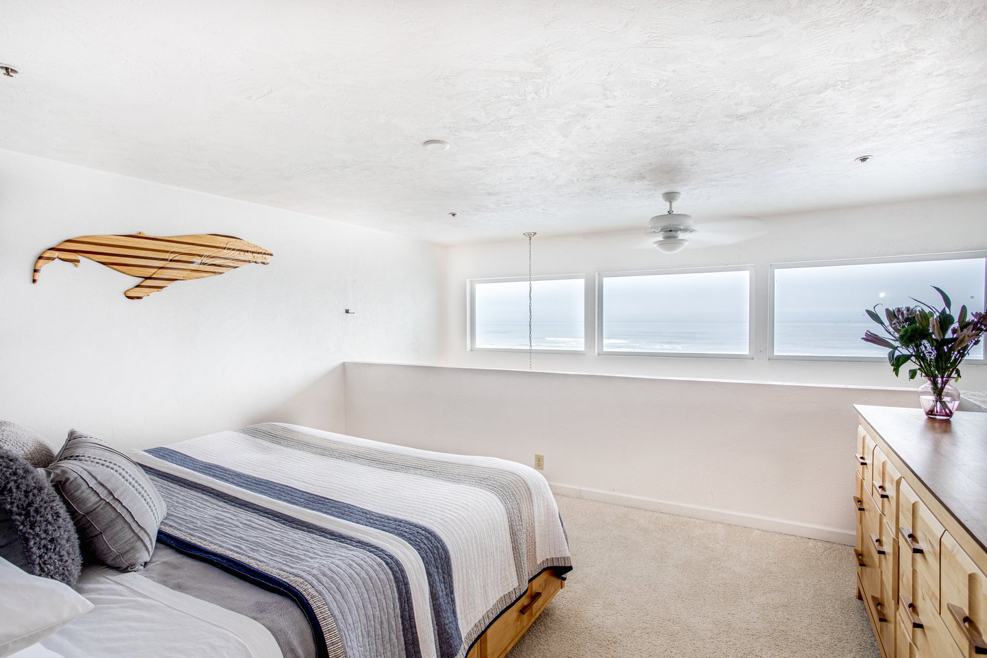 Upstairs is a second loft style bedroom also with en suite bath and ceiling fan.
