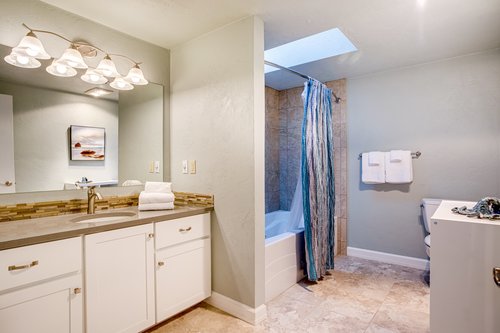 A clean and bright bath with tile floors and tub/shower