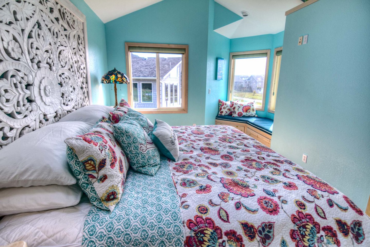 Mainfloor bedroom with beautiful carved king headboard and a quiet window seat to enjoy the view.
