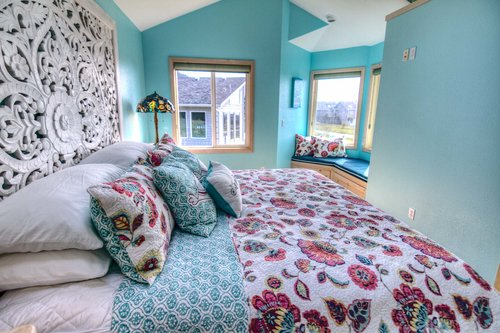 Mainfloor bedroom with beautiful carved king headboard and a quiet window seat to enjoy the view.