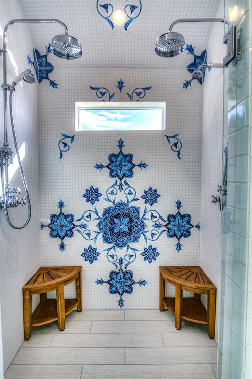 Gorgeous tile work in this double shower head walk in shower.