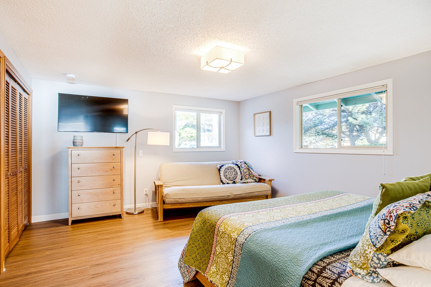 Spacious master bedroom with king bed and futon for extra sleeping space.