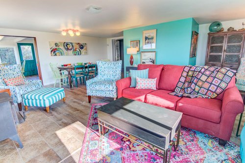 Sunny and bright living room has a sleeper sofa for extra sleeping space.