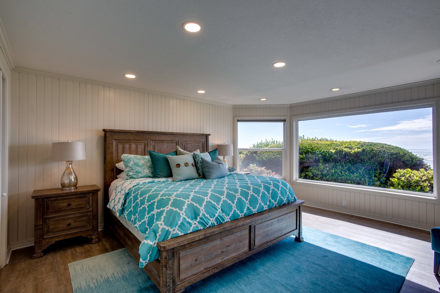 Large primary bedroom with ocean views and television.