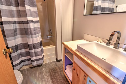 This bathroom is in the hallway with the bedrooms and has a tub/shower combination.