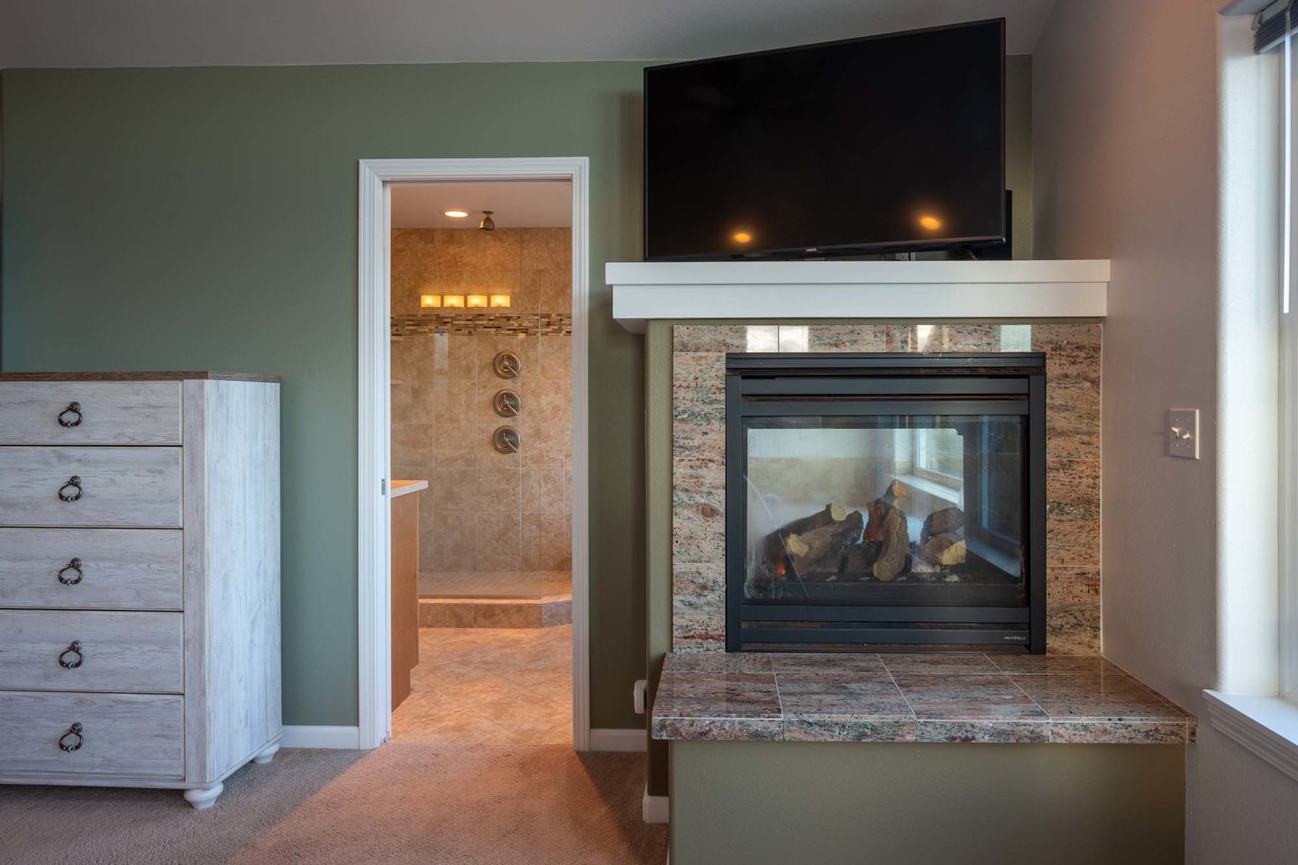 Enjoy the see-through fire place and large screen television from the comforts of bed.