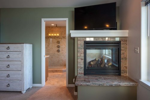 Enjoy the see-through fire place and large screen television from the comforts of bed.