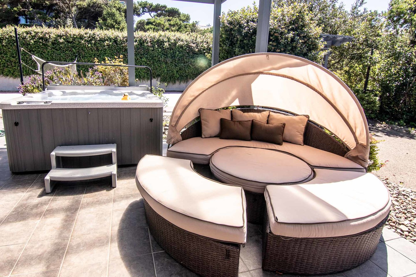 Relax under the covered patio and enjoy either the patio daybed or the hot tub!