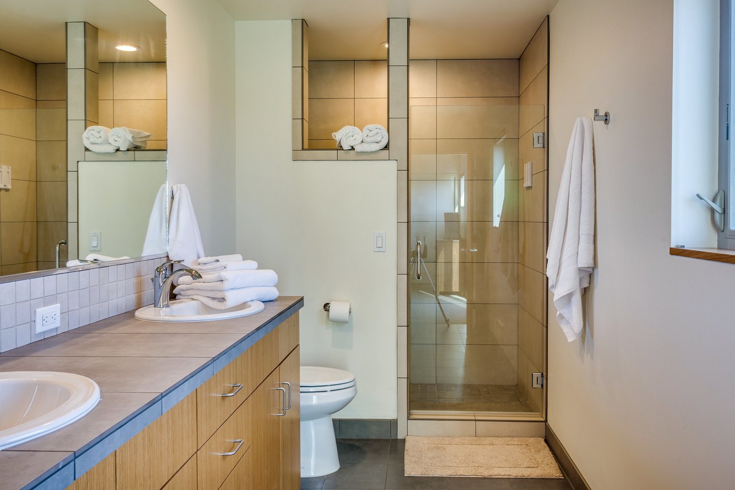 Attached to the downstairs queen bedroom is a beautiful bathroom with a tiled walk in shower.