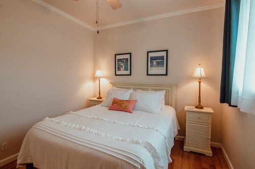 A queen size bedroom at the end of the hall.