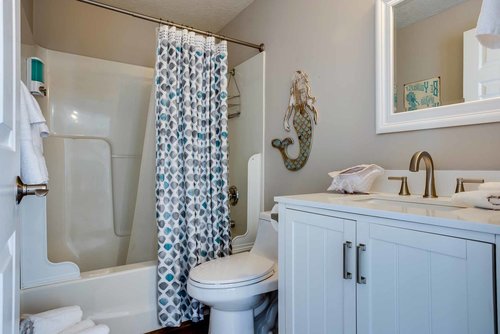 The bath in the hallway with a tub/shower enclosure.