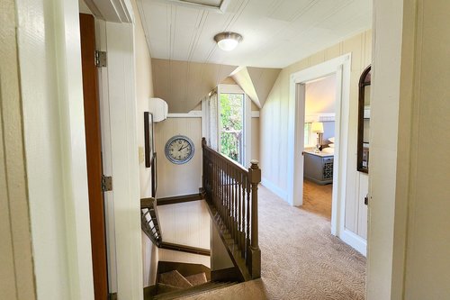 Up the stairs is a hallway with a door to a small balcony to let in fresh salt air.