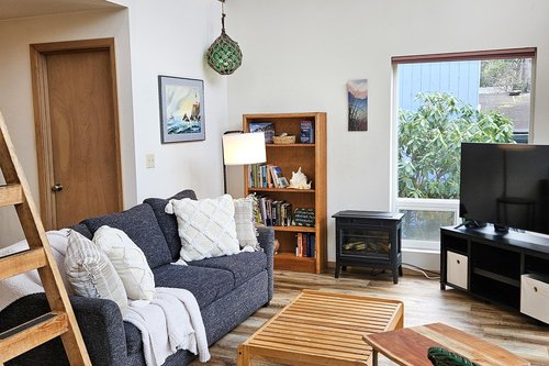 Cozy couch with TV and electric fireplace.