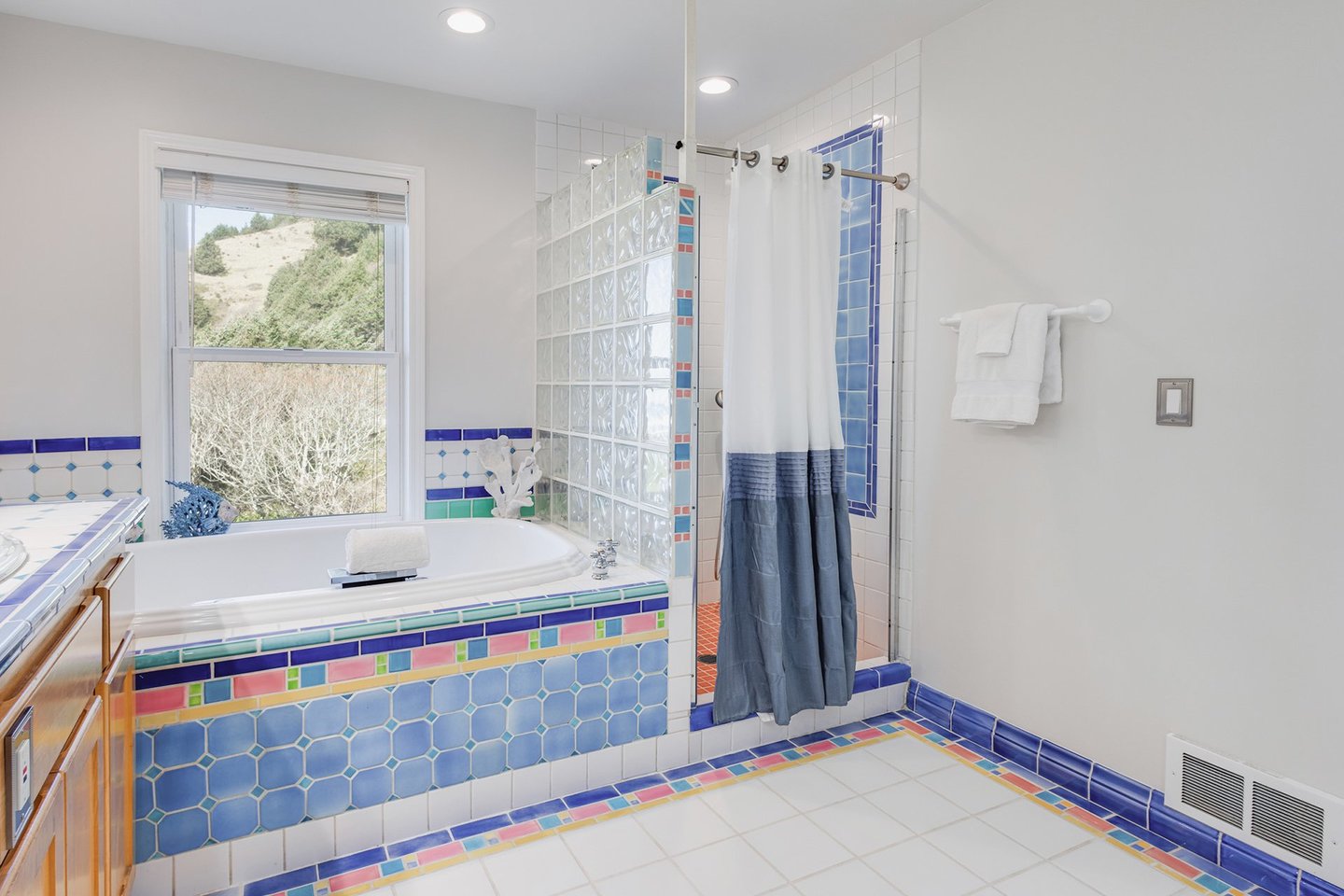 This large bath is part of the primary suite. It has both a tub and a walk in shower.
