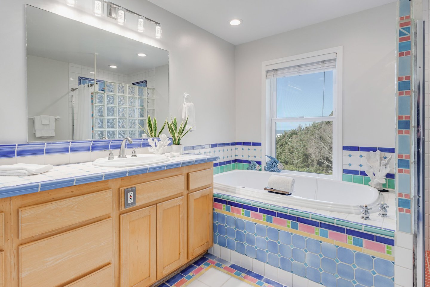Colorful tile show off the large soaking tub.