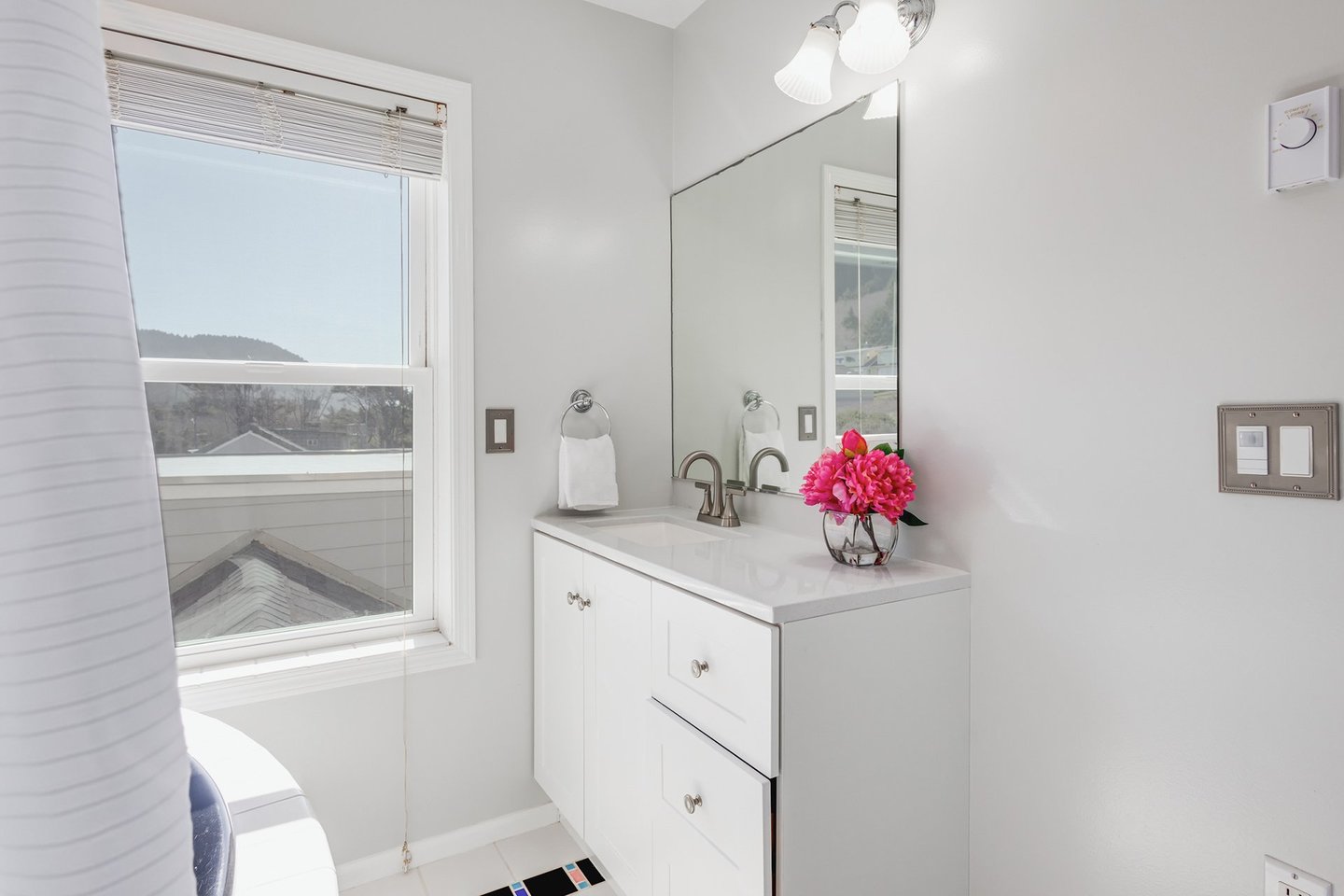 The ensuite bath has a vanity and bath tub/shower wand.