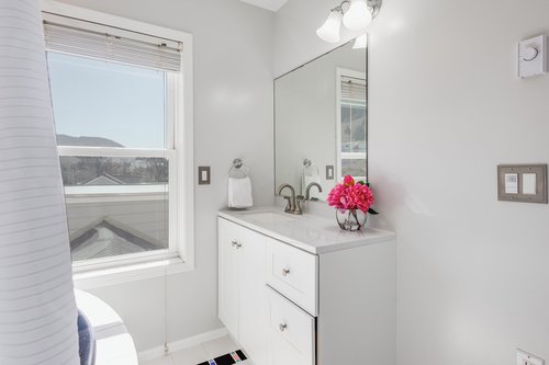 The ensuite bath has a vanity and bath tub/shower wand.