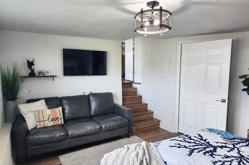 The spacious primary bedroom has a sofa and television.