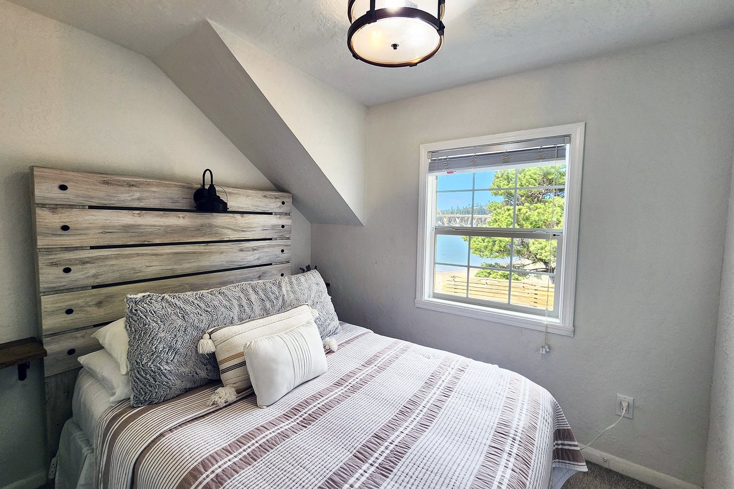 The third bedroom upstairs has a comfy queen bed and peeks of the bay.