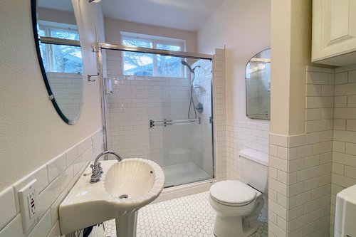 The bath in the hallway with a walk in shower.