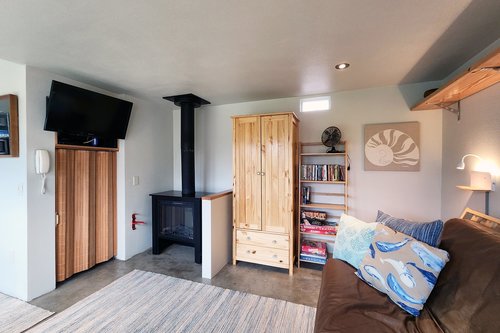 Cozy living space with electric fire, TV and futon.